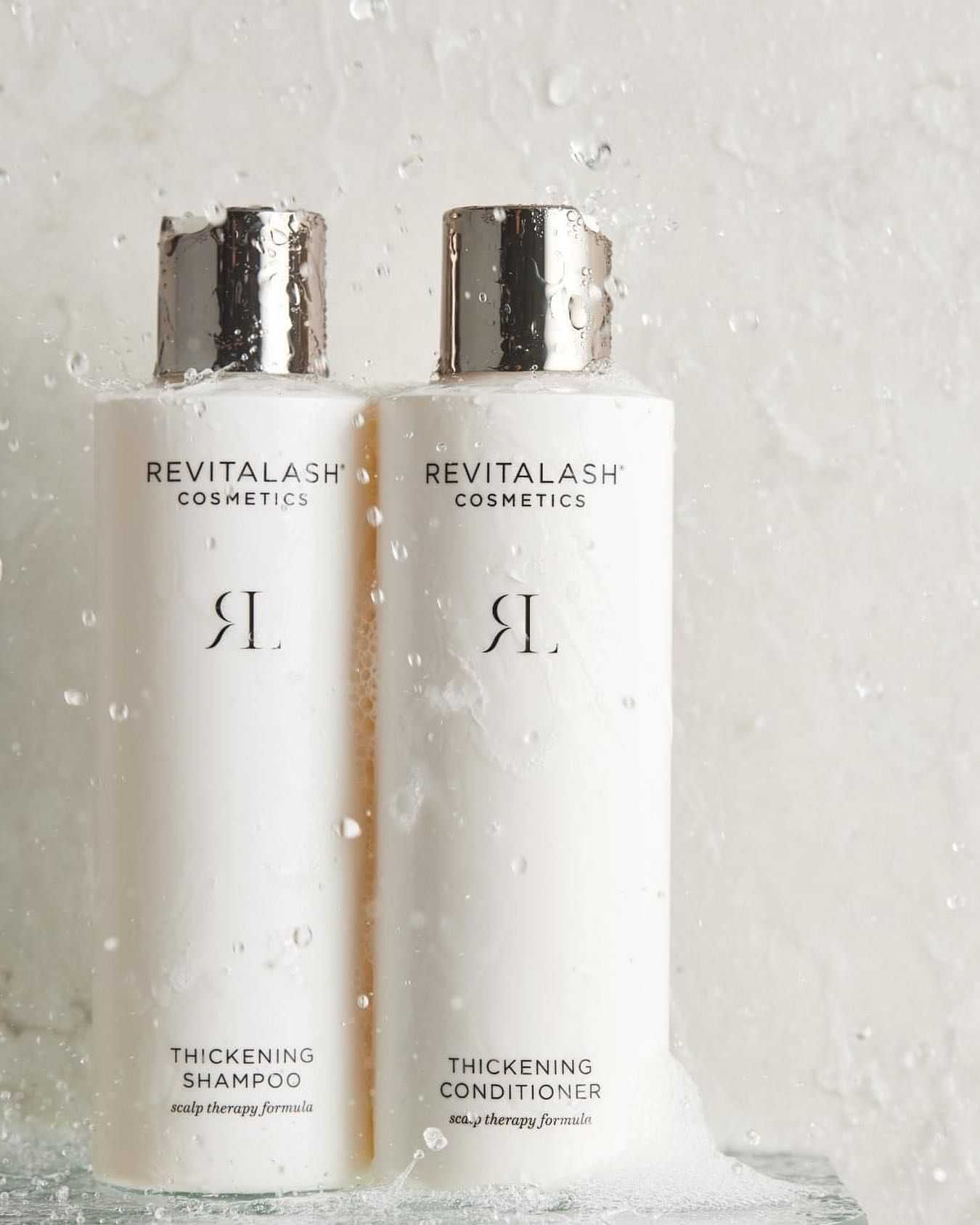 RevitaLash shampoo and conditioner bottles with water droplets.